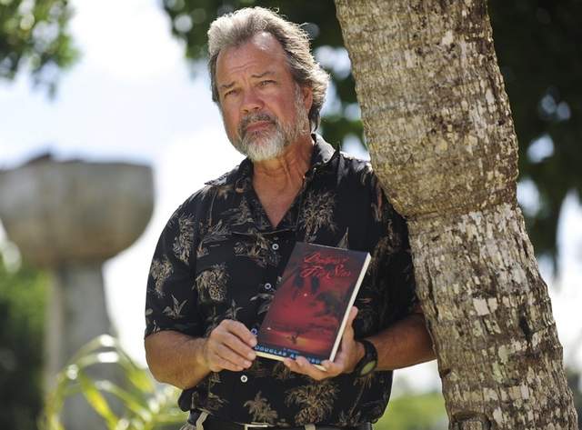 <B>Author: </B>Douglas Arvidson is photographed holding a copy of "Brothers of the Fire Star" at Ypao Beach Park in Tumon on Oct. 25. Rick Cruz/Pacific Sunday News/rmcruz@guampdn.com